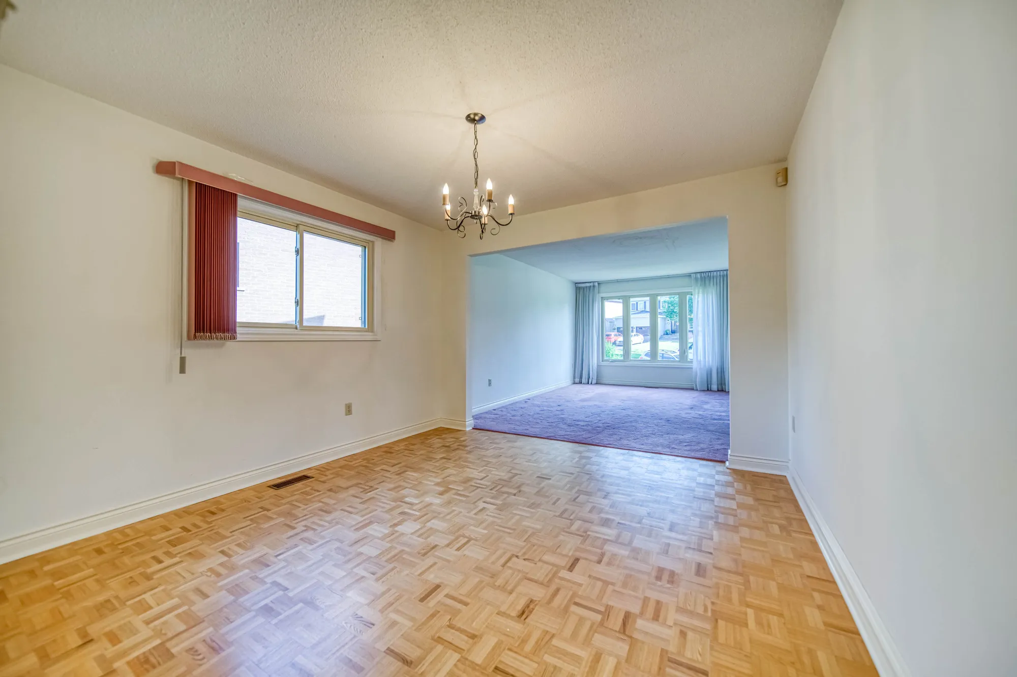 The dining room before: parquet floor and a brass chandelier.