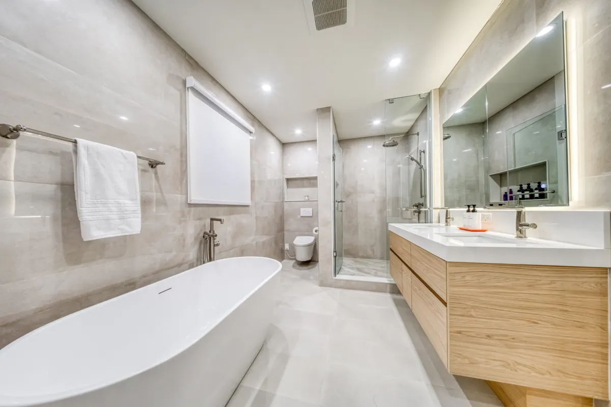 The finished ensuite: a freestanding tub, a floating oak double vanity and a glass shower.