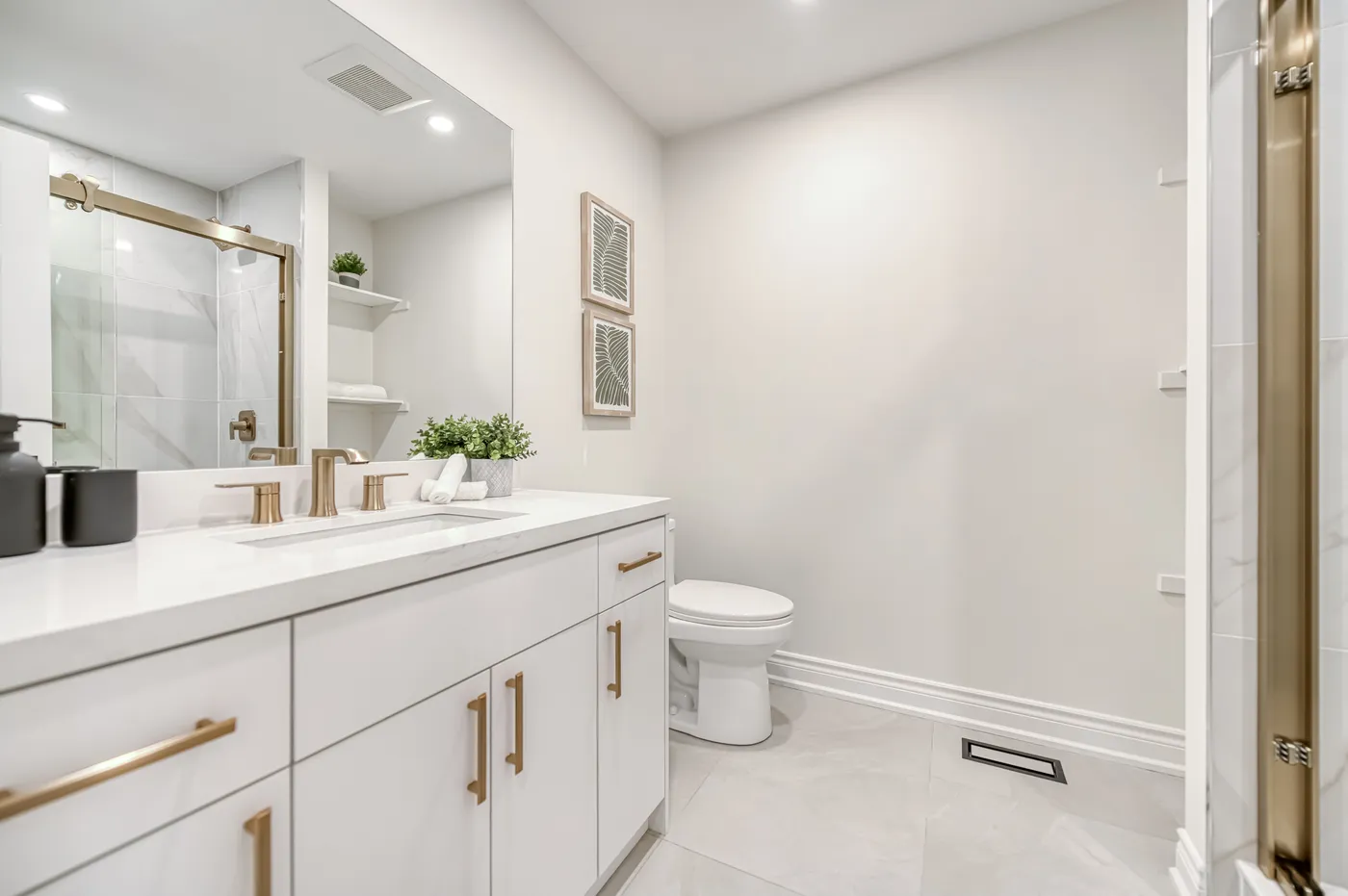 A bathroom with a white vanity and a glass shower.