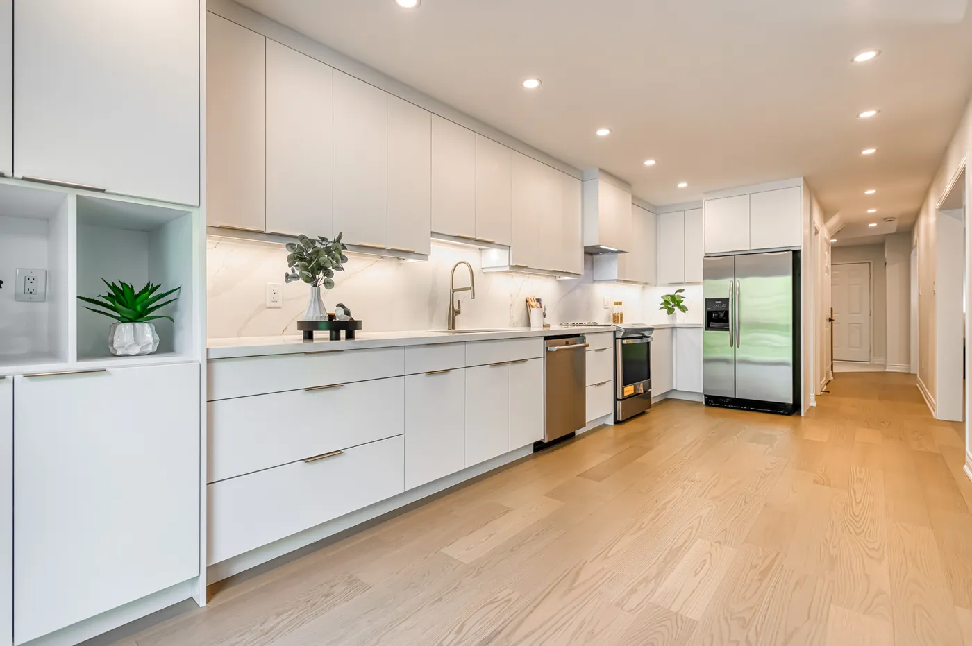 The kitchen: a long run of flat white cabinets.