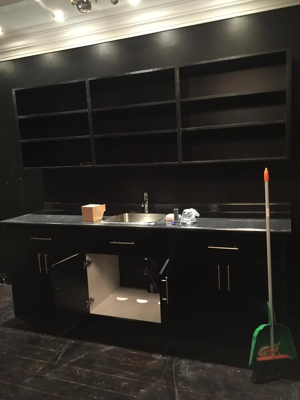 The back bar before: black shelving and a steel sink.